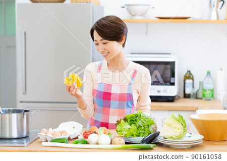 Middle-aged woman in the kitchen Middle-aged woman in the kitchen 90161058