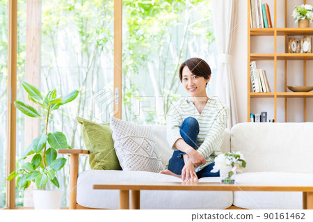 A middle-aged woman relaxing in the living room 90161462