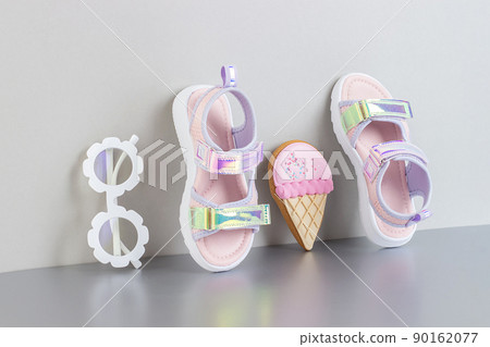 Stylish holographic sandals for kids on grey background. Shiny fashion summer shoes Stylish holographic sandals for kids on grey background. Shiny fashion summer shoes 90162077
