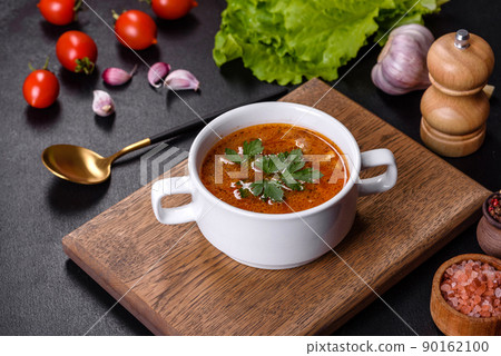 Fresh delicious tomato soup with spices and parsley in a white bowl on a wooden board Fresh delicious tomato soup with spices and parsley in a white bowl on a wooden board 90162100