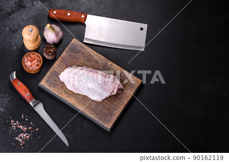 Fresh raw turkey wing with spices and herbs on a wooden cutting board Fresh raw turkey wing with spices and herbs on a wooden cutting board 90162119
