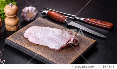 Fresh raw turkey wing with spices and herbs on a wooden cutting board 90162121