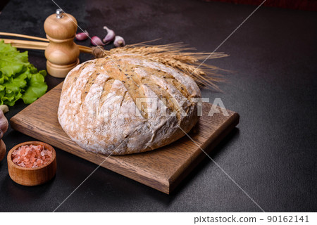 White round bread with flax seeds on a cutting board White round bread with flax seeds on a cutting board 90162141