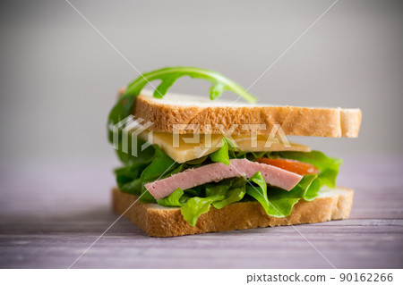sandwich with various greens, cheese, sausage, tomato sandwich with various greens, cheese, sausage, tomato 90162266