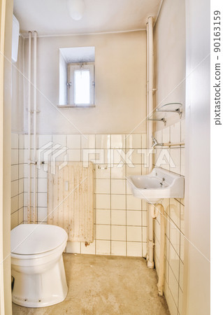 The interior of a spacious bathroom in a cozy apartment with a sink and toilet 90163159