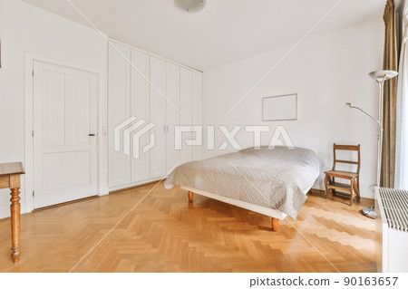 An empty bedroom with a small bed and access to the balcony 90163657