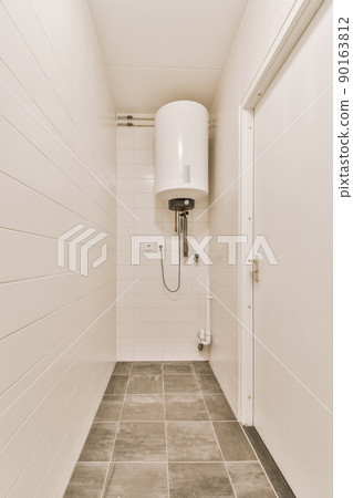 View of a bathroom with a boiler system surrounded by white tiles in a modern house View of a bathroom with a boiler system surrounded by white tiles in a modern house 90163812
