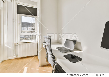 Comfortable chair placed near desk with computer monitors and whiteboard in light workplace in modern apartment 90163948