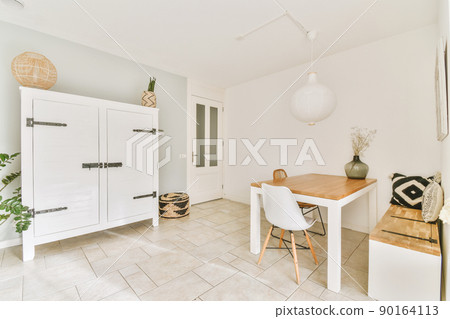 A small dining area with a table and two chairs on the tiled floor in a modern house 90164113