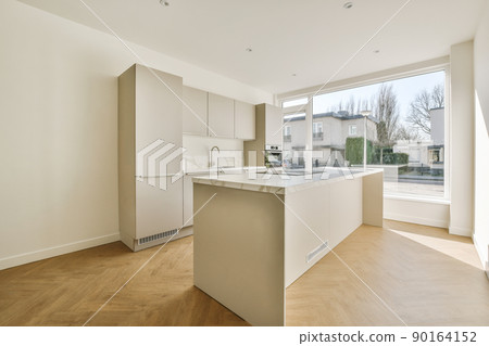Interior of empty white kitchen with windows and wooden parquet floor Interior of empty white kitchen with windows and wooden parquet floor 90164152