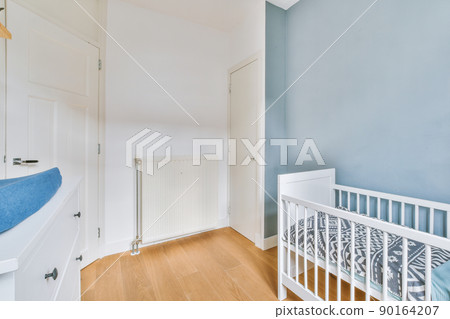 A spacious children's room with a bed with fences in bright colors in a cozy modern house 90164207