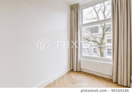 Plastic window and radiator on white wall in empty light room at home 90164286