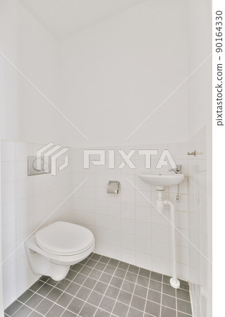 Bathroom with white and black tiles and ceramic toilet and sink in a modern house 90164330