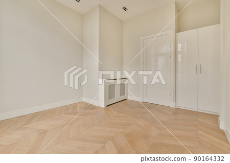 Modern cupboard and vintage chest placed near doors and wicker basket in spacious room with white walls and wooden floor Modern cupboard and vintage chest placed near doors and wicker basket in spacious room with white walls and wooden floor 90164332