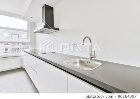 Corner kitchen of a light shade in a minimalist style in a studio apartment Corner kitchen of a light shade in a minimalist style in a studio apartment 90164397