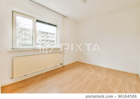 Plastic window and radiator on white wall in empty light room at home Plastic window and radiator on white wall in empty light room at home 90164508
