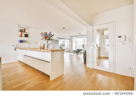 Modern minimalist style interior design of studio apartment with open white kitchen, and dining zone with table and chairs 90164560