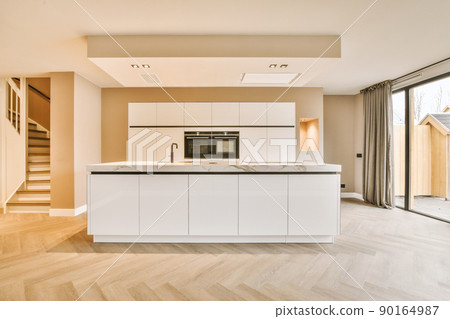 A minimalist kitchen with a block system in white design and access to the backyard A minimalist kitchen with a block system in white design and access to the backyard 90164987