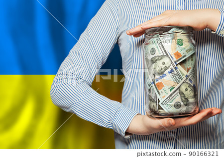 Blue and yellow color Ukrainian flag and US dollars money in human hand. Save Ukraine Blue and yellow color Ukrainian flag and US dollars money in human hand. Save Ukraine 90166321