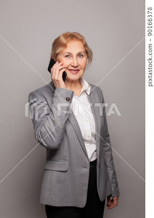 Portrait of a happy senior woman on the phone 90166378