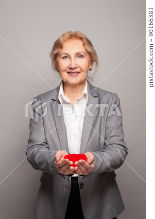 Attractive woman smiling and holding red heart in her hands 90166381