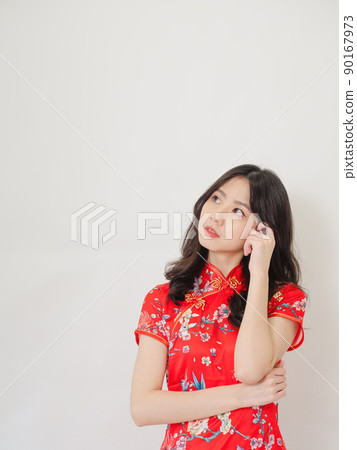 Portrait of Young asian woman wearing traditional cheongsam qipao dress thinking with hand on head isolated over white background. 90167973