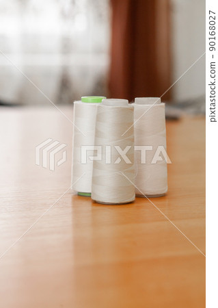 Reels with white threads for a sewing machine in atelier Reels with white threads for a sewing machine in atelier 90168027