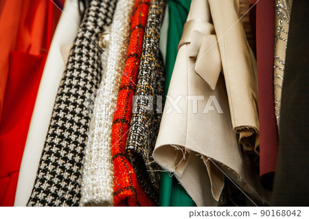 Unfinished fashionable tailored clothes in atelier close up. Modern premium quality hand made woman's clothes 90168042