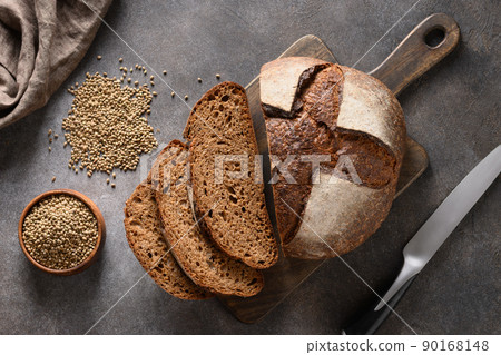 Loaf of freshly baked hemp bread and hemp seeds on gray background. Loaf of freshly baked hemp bread and hemp seeds on gray background. 90168148