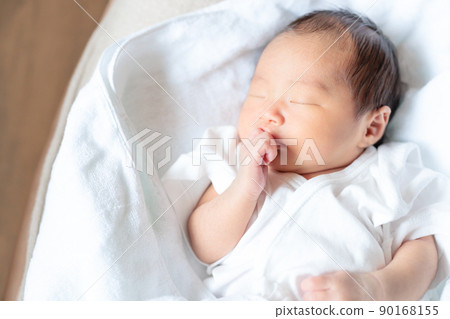 7-day-old baby's finger sucking copy space 90168155