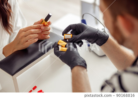 Nail technician with nail polishes in manicure salon Nail technician with nail polishes in manicure salon 90168816
