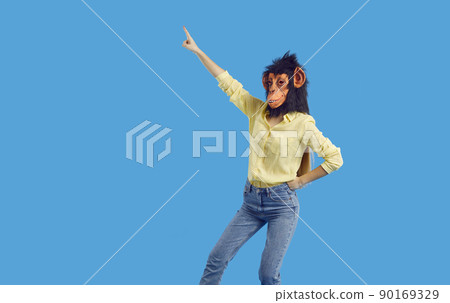 Cheerful woman funny monkey mask having fun isolated on vivid light blue background. Cheerful woman funny monkey mask having fun isolated on vivid light blue background. 90169329