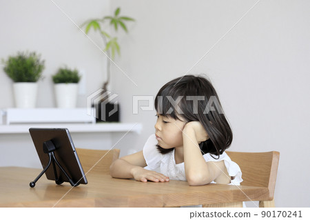 Watching videos on a tablet Elementary school girl (7 years old) Watching videos on a tablet Elementary school girl (7 years old) 90170241