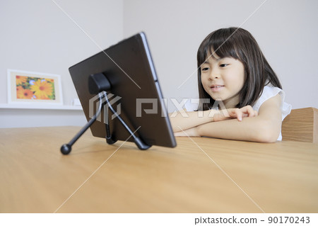 Watching videos on a tablet Elementary school girl (7 years old) Watching videos on a tablet Elementary school girl (7 years old) 90170243