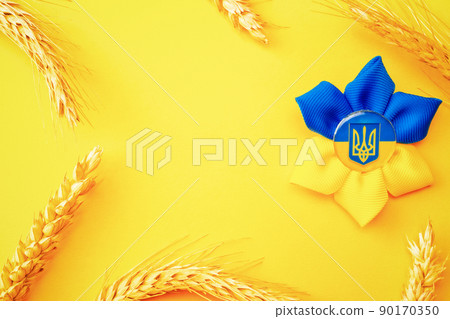 Ukraine flag symbol background. Ukrainian flower trident symbol with wheat grain ear isolated on yellow banner. Support Ukraine concept. Ukraine flag symbol background. Ukrainian flower trident symbol with wheat grain ear isolated on yellow banner. Support Ukraine concept. 90170350