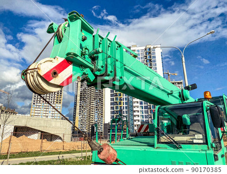 The boom-type crane moves without a load, without requiring special tracks. truck crane at the construction site of a new microdistrict, heavy automotive equipment 90170385