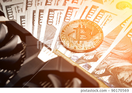 The coin of bitcoin lies on dollars with video card. Exchange bitcoin cash for a dollar. Sun flare 90170569