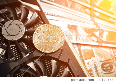 The coin of bitcoin lies on video card with dollars. Exchange bitcoin cash for a dollar. Sun flare The coin of bitcoin lies on video card with dollars. Exchange bitcoin cash for a dollar. Sun flare 90170578