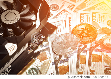 The coins of bitcoin lies on dollars with video card. Exchange bitcoin cash for a dollar. Sun flare 90170584