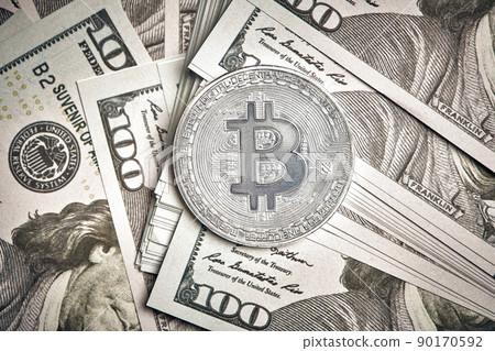 A symbolic coins of bitcoin on banknotes of one hundred dollars. Exchange bitcoin cash for a dollar. A symbolic coins of bitcoin on banknotes of one hundred dollars. Exchange bitcoin cash for a dollar. 90170592