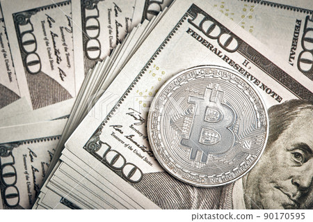 A symbolic coins of bitcoin on banknotes of one hundred dollars. Exchange bitcoin cash for a dollar. A symbolic coins of bitcoin on banknotes of one hundred dollars. Exchange bitcoin cash for a dollar. 90170595
