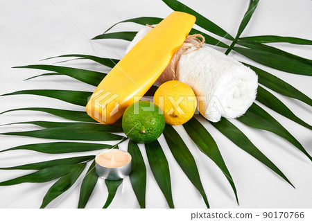 Natural cosmetics for home spa. Top view bottle of cream with essential oil, fresh lime fruit, green leaf decor, white background Natural cosmetics for home spa. Top view bottle of cream with essential oil, fresh lime fruit, green leaf decor, white background 90170766
