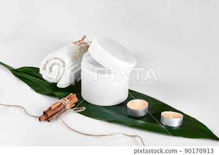 Skin care beauty treatment with jar of body moisturizer. White body lotion with big green leaf on light background. 90170913