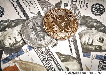 A symbolic coins of bitcoin on banknotes of one hundred dollars. Exchange bitcoin cash for a dollar. A symbolic coins of bitcoin on banknotes of one hundred dollars. Exchange bitcoin cash for a dollar. 90170920