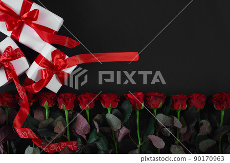 White gift boxes with red ribbon on black background. Valentines day greeting card. 90170963