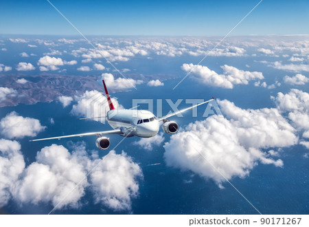 Airplane is flying above the clouds at sunset in summer 90171267