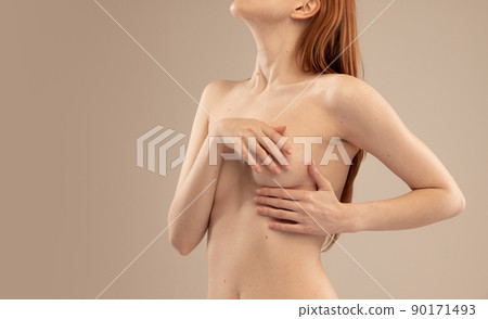 Cropped image of slim female body, breast isolated over beige studio background. Mammoplasty Cropped image of slim female body, breast isolated over beige studio background. Mammoplasty 90171493