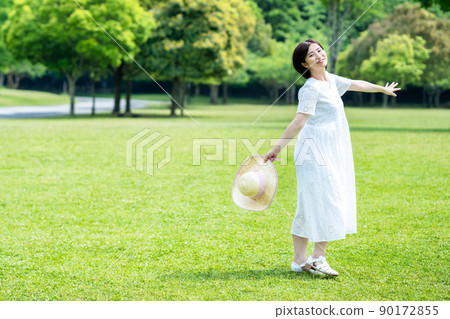 A woman refreshing on the fresh green grass A woman refreshing on the fresh green grass 90172855
