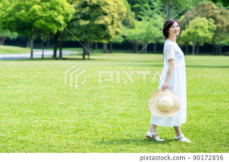 A woman refreshing on the fresh green grass 90172856
