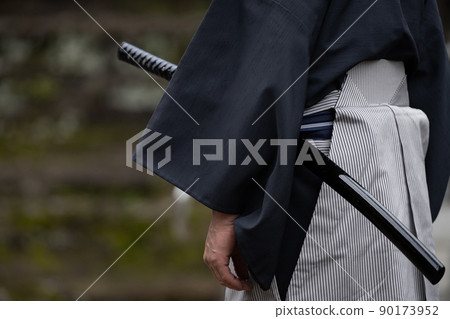 A person holding a Japanese sword 90173952